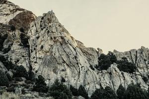rocky mountain under cloudy sky